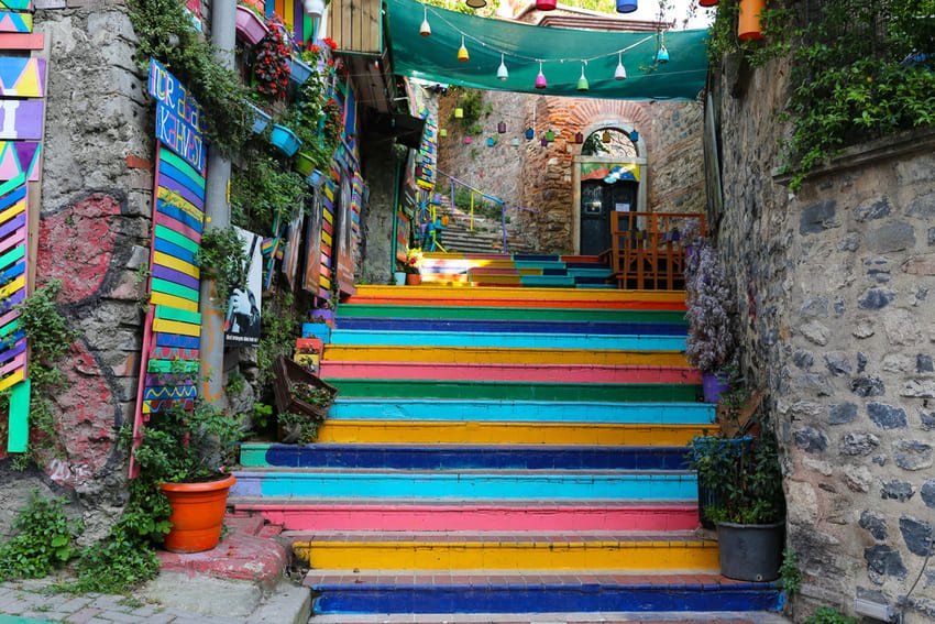Les célèbres escaliers colorés arc-en-ciel du quartier historique de Balat et Fener à Istanbul, entourés de vieux murs en pierre et de petits cafés traditionnels.